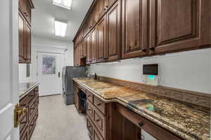 Laundry area with light tile patterned floors, cabinet space, and separate washer and dryer