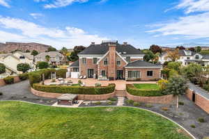 Rear view of house with a patio area, a mountain view, a fenced backyard, and a residential view