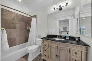 Full bath featuring crown molding, vanity, shower / bathtub combination with curtain, and ensuite bath