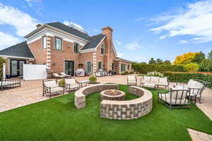 Rear view of house with a chimney, a patio area, brick siding, and french doors