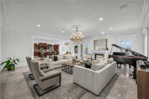 Living area featuring ornamental molding, recessed lighting, a chandelier, and a fireplace
