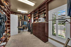 Spacious closet with light carpet