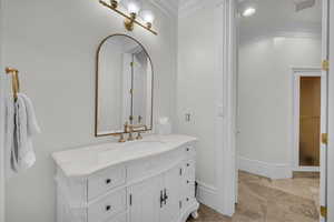 Bathroom with crown molding and vanity