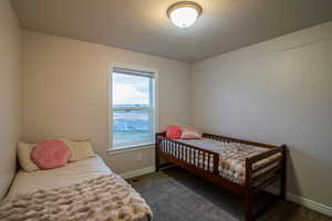 Bedroom featuring dark colored carpet and a textured ceiling