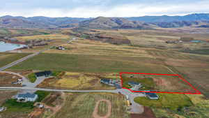 Aerial view of sparsely populated area featuring property boundaries highlighted and a water and mountain view