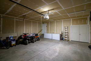 Garage with white refrigerator and a garage door opener