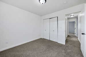 Unfurnished bedroom featuring carpet flooring and a closet