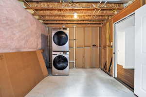 Unfinished basement with stacked washer / drying machine