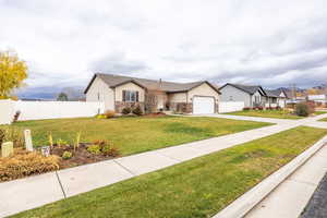 Single story home featuring concrete driveway, stone siding, a residential view, and a garage