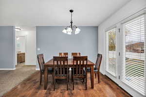 Dining area with dark wood-style floors and a chandelier