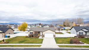 Traditional home featuring a residential view, driveway, a fenced backyard, stone siding, and a gate