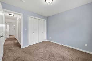 Unfurnished bedroom with carpet floors and a closet