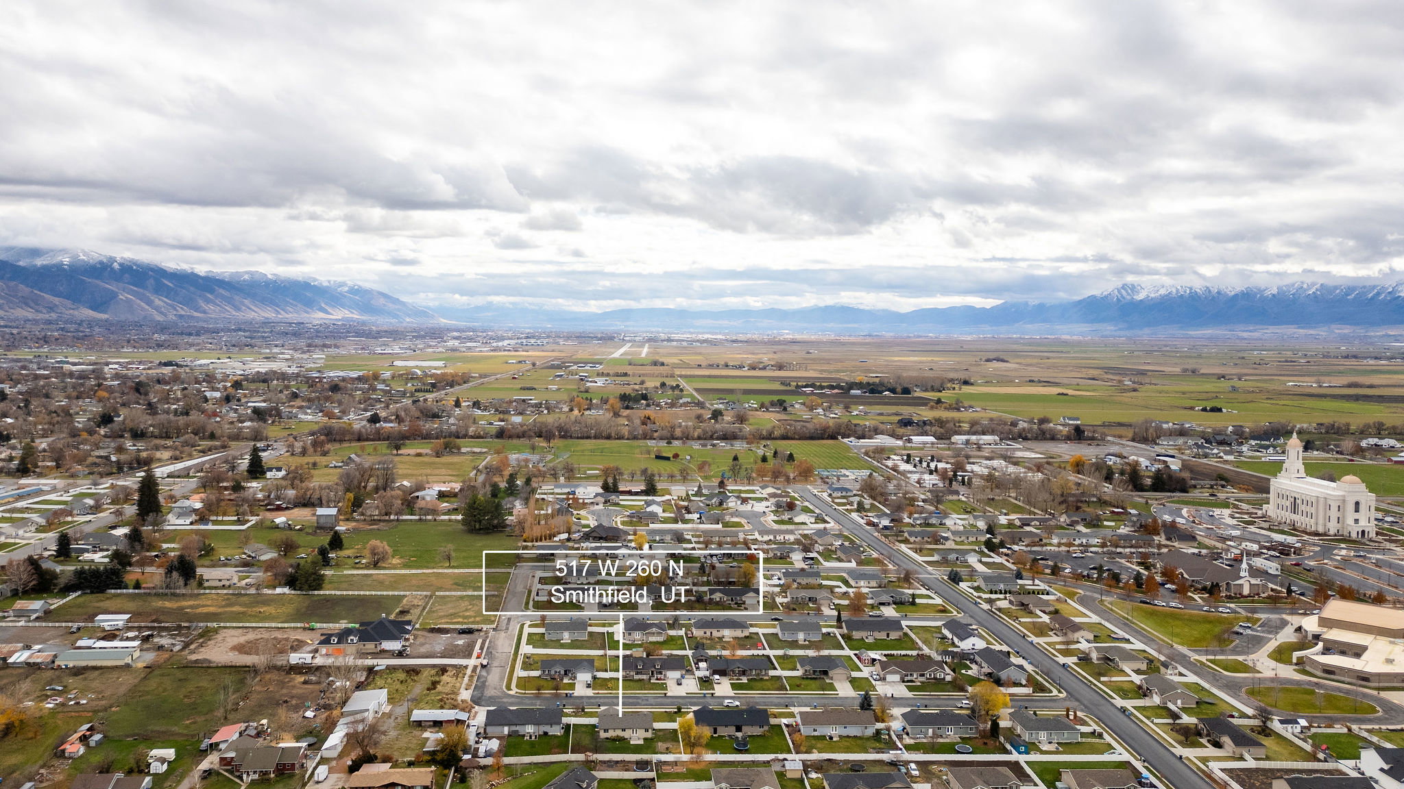 Aerial overview of property's location featuring nearby suburban area and a mountain backdrop