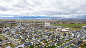 Aerial view of property and surrounding area with a mountain backdrop and nearby suburban area