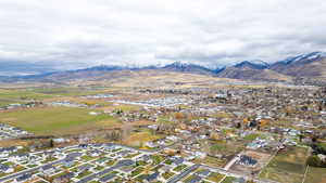 Aerial view of property and surrounding area with nearby suburban area and a mountain backdrop