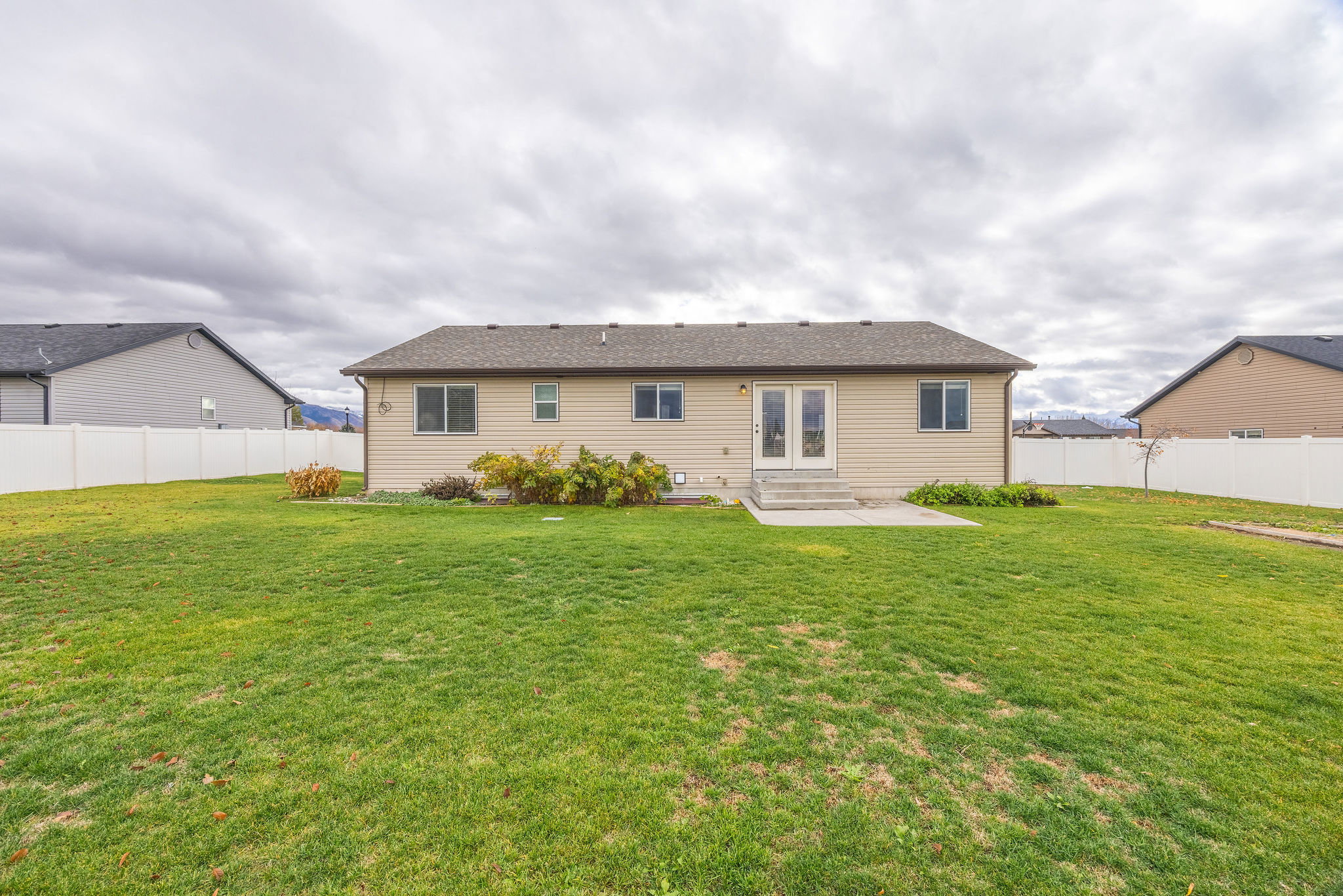 Back of property with a patio, a fenced backyard, french doors, and roof with shingles