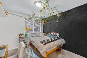 Bedroom featuring carpet and a textured ceiling