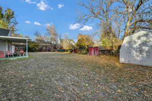 View of yard with a storage unit and a patio area