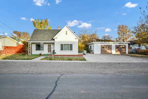 Bungalow featuring an outbuilding, a chimney, a porch, roof with shingles, and stucco siding