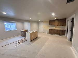 Kitchen with recessed lighting, a kitchen island, and brown cabinets
