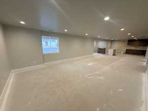 Unfurnished living room featuring recessed lighting and baseboards