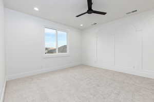 Spare room featuring light colored carpet, a ceiling fan, and recessed lighting
