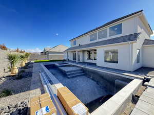 Back of property with a patio area, stucco siding, a fenced backyard, and a pool with connected hot tub