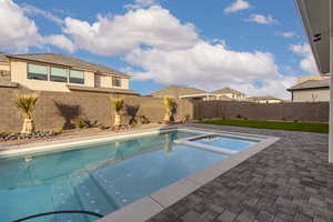 View of swimming pool featuring a fenced backyard, a patio, and a pool with connected hot tub