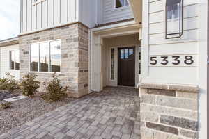 Property entrance featuring board and batten siding and stone siding