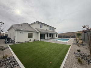 Rear view of house featuring a fenced backyard, a patio, stucco siding, and a tile roof