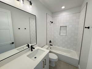 Bathroom with vanity, shower / bathtub combination, tile patterned flooring, and recessed lighting