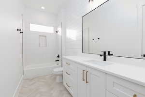 Bathroom featuring tub / shower combination, vanity, and parquet flooring