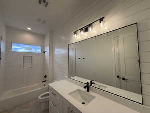 Bathroom featuring bathing tub / shower combination, vanity, and recessed lighting