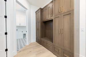 Mudroom with light wood-style floors and baseboards