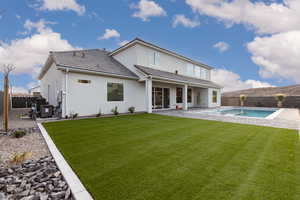 Back of house featuring a fenced backyard, a patio, a tile roof, and stucco siding