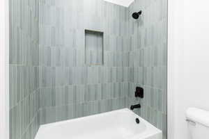 Full bath featuring toilet and shower / washtub combination