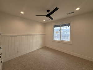 Unfurnished room with carpet flooring, recessed lighting, a ceiling fan, and a wainscoted wall