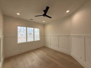 Empty room featuring a wainscoted wall, a decorative wall, light wood finished floors, recessed lighting, and ceiling fan