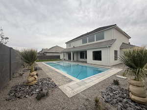 Rear view of property with a patio, a fenced backyard, and stucco siding