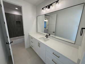 Full bath featuring vanity,  shower combination, light tile patterned floors, and recessed lighting