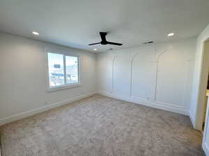 Empty room featuring light colored carpet, recessed lighting, and ceiling fan