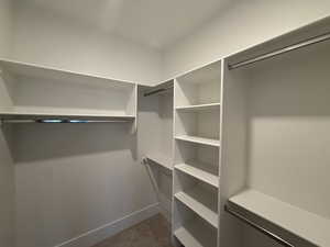 Spacious closet with dark carpet