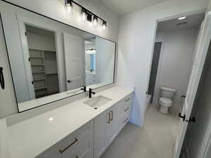 Bathroom featuring vanity, a spacious closet, and light tile patterned flooring