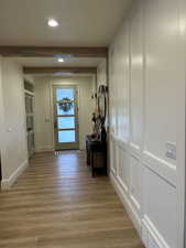 Hallway featuring light wood-style floors, beam ceiling, and recessed lighting