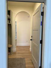 Corridor with light wood finished floors and arched walkways