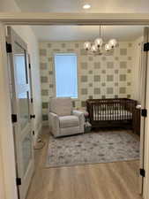 Living area featuring a chandelier, light wood finished floors, and plenty of natural light