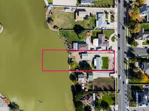 Aerial view of residential area with property parcel outlined and a nearby body of water