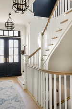 Entrance foyer featuring stairway, wood finished floors, and ornamental molding