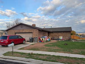 Single story home with brick siding, concrete driveway, an attached garage, and a chimney