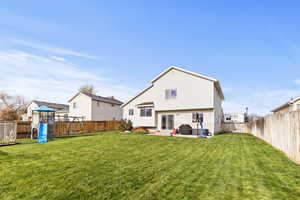 Rear view of property featuring a fenced backyard, a patio, and a playground